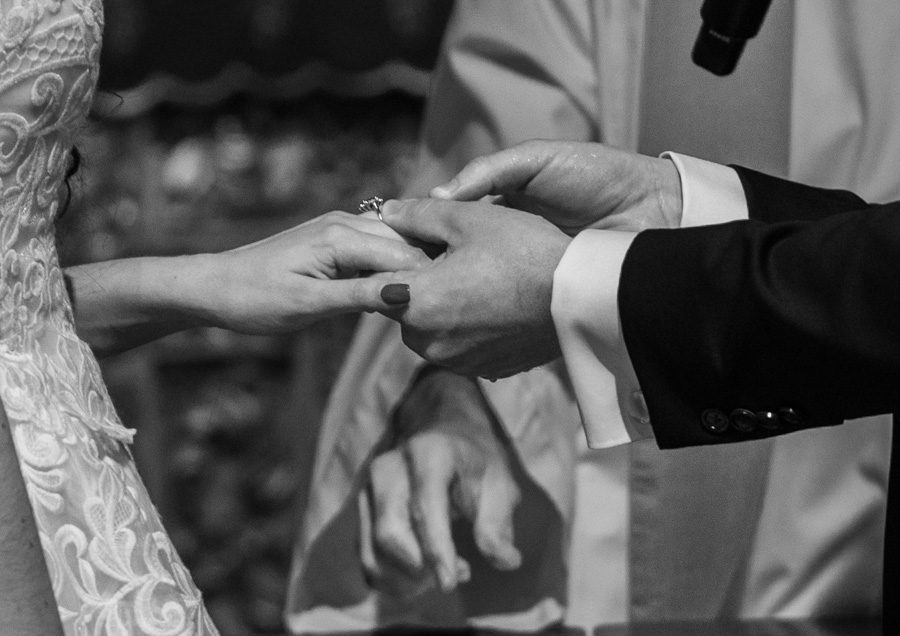 Groom places ring on bride's hand