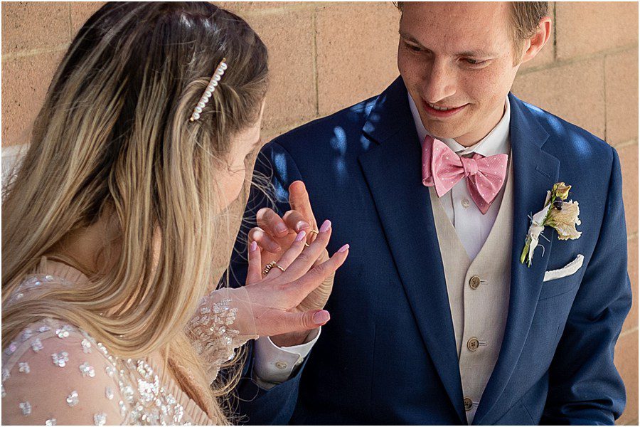 Groom places ring on bride for zoom wedding elopement