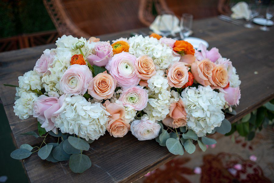 close up of floral with roses on the sweetheart table in the beverly park west outdoor space