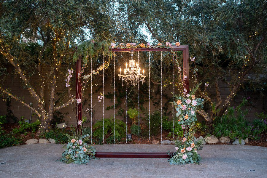 gorgeous wedding arch frame with sparkling chandelier at the garland  beverly park outdoor venue