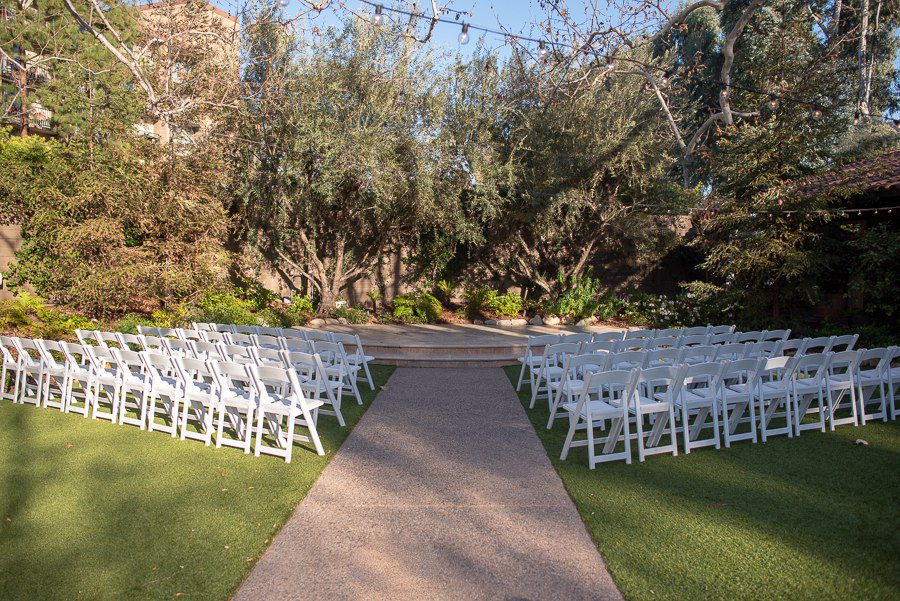 Walk way leading to the ceremony  stage. White chairs for the wedding guests perfectly lined up on each side 
