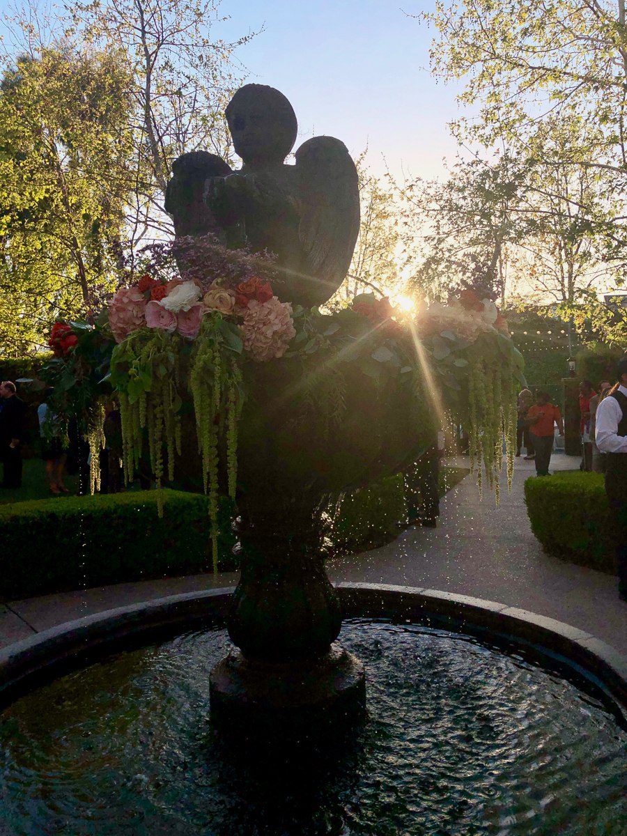 sun going down behind stone fountain at the garland beverly park
